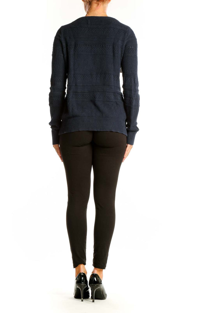 Side view of woman wearing LOFT navy textured cotton knit sweater with black pants