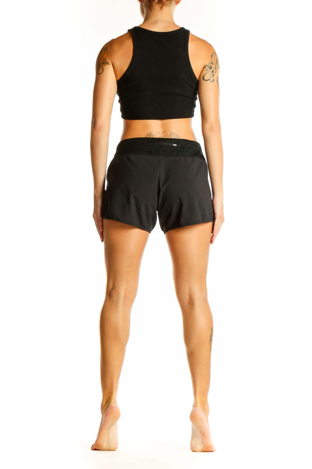 Side view of woman wearing black Nike performance running shorts and crop top