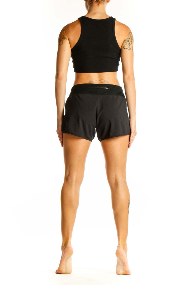 Side view of woman wearing black Nike performance running shorts and crop top