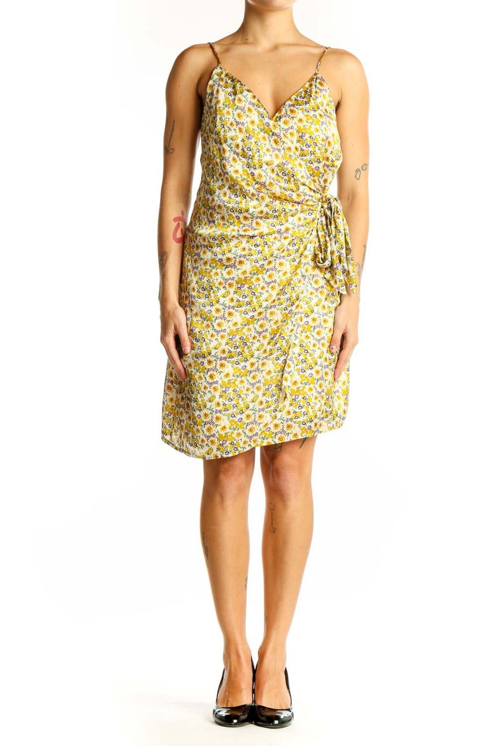 Front view of yellow floral wrap mini dress with spaghetti straps and side tie