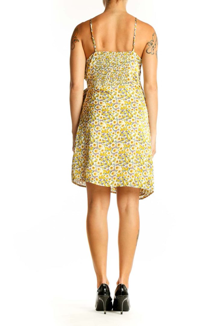 Side view of yellow floral wrap mini dress showing flattering silhouette