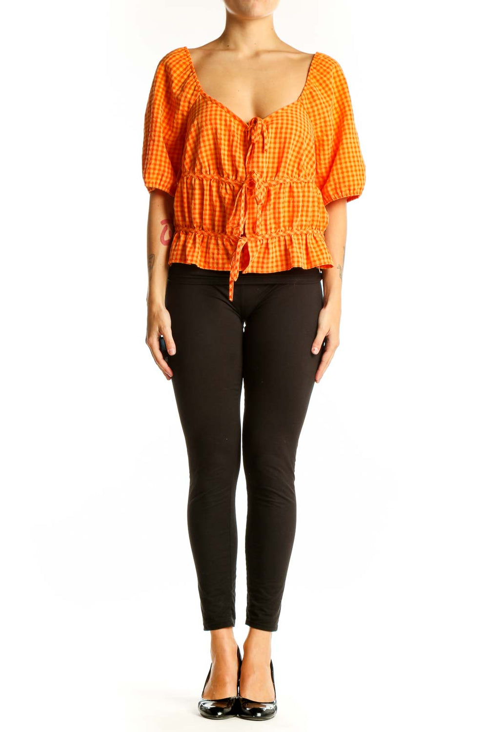 Front view of orange gingham crop top with puff sleeves and tie front