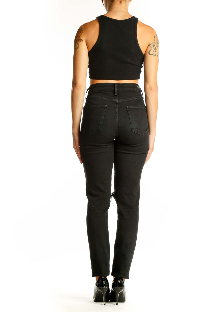 Side view of woman wearing C of H black distressed high-waist skinny jeans
