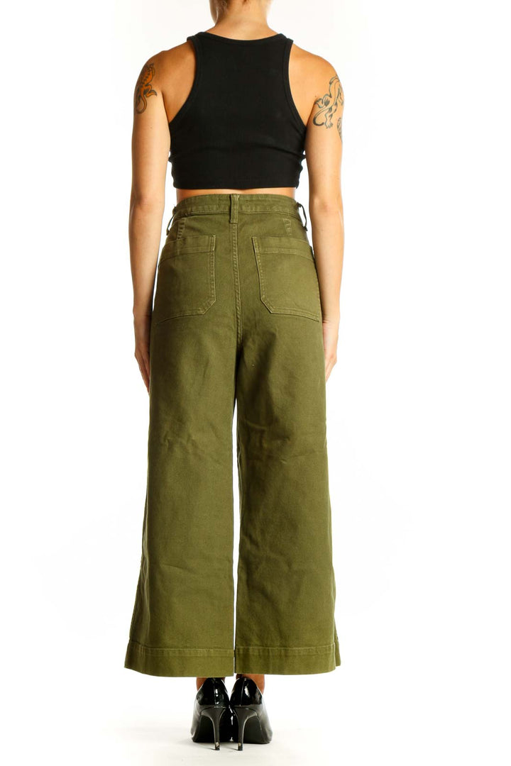 Side view of woman wearing olive Madewell wide-leg pants with black top