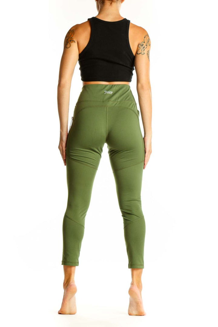 Side view of woman wearing olive green high-waisted activewear leggings with black crop top