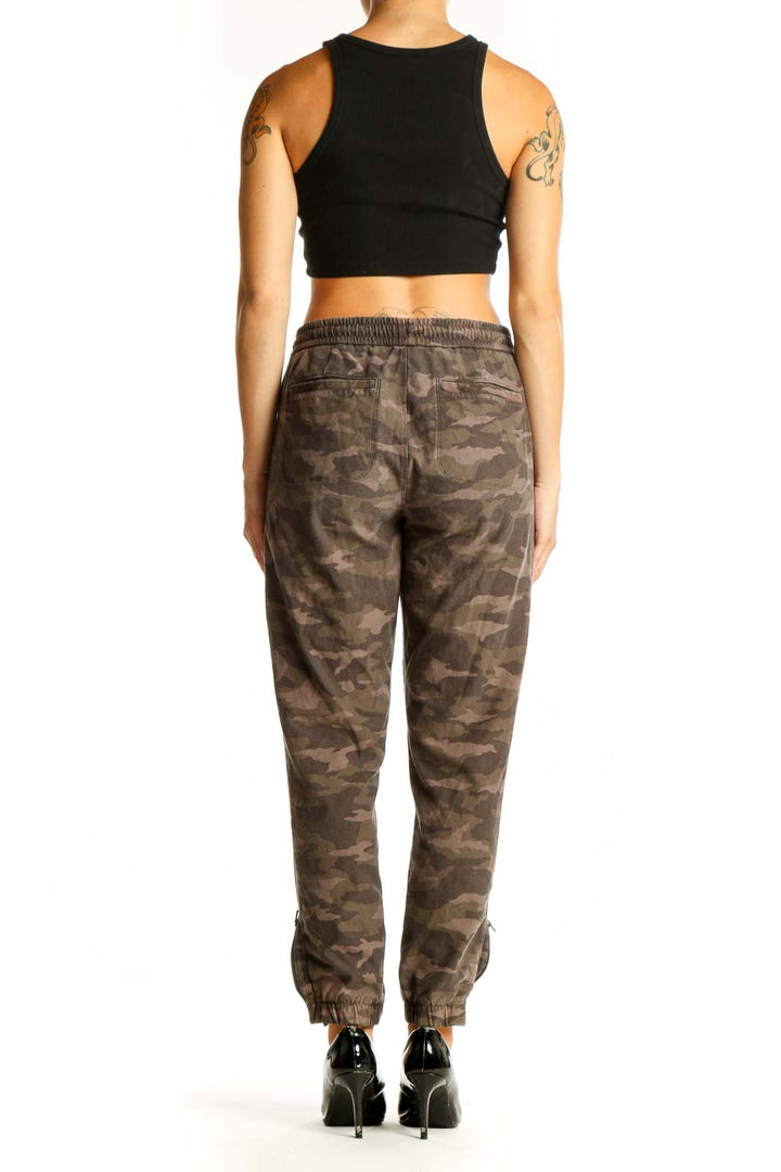 Side view of woman wearing Athleta brown camo jogger pants with black crop top