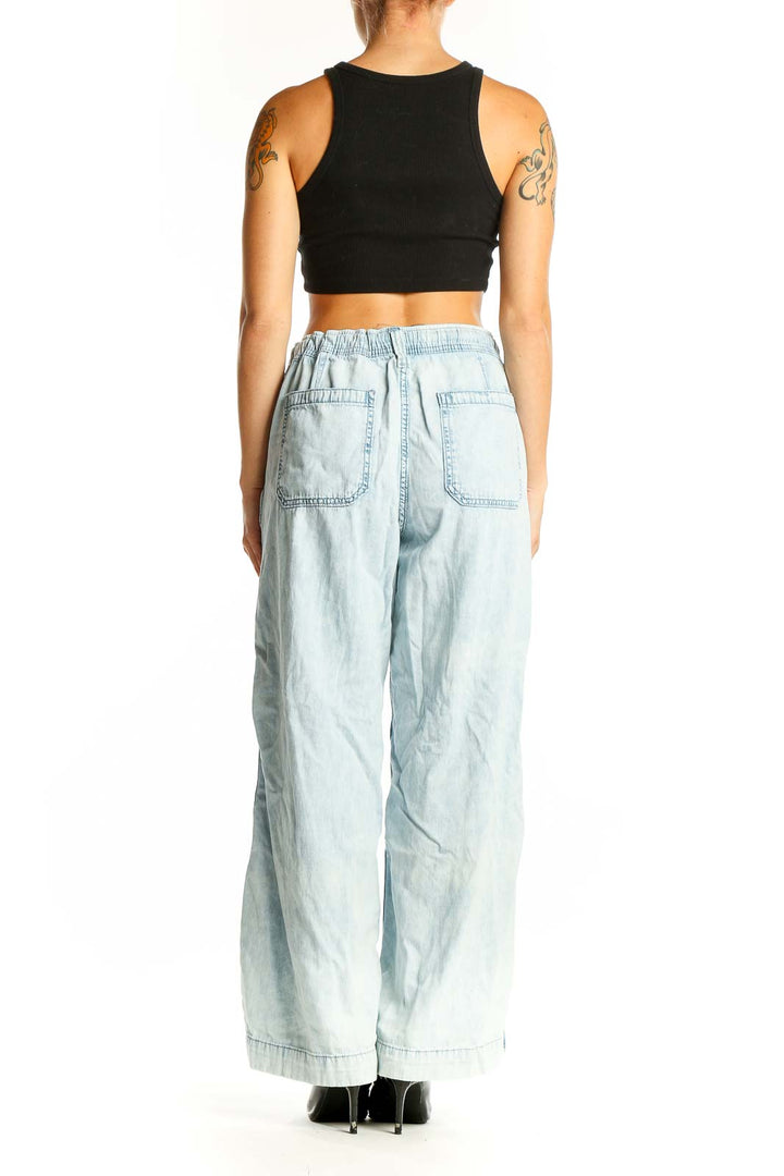 Side view of woman wearing light blue wide-leg cotton pants from Gap with black crop top