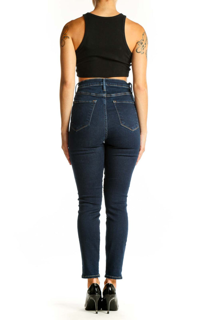 Back view of FRAME dark blue high-waisted skinny jeans with black crop top