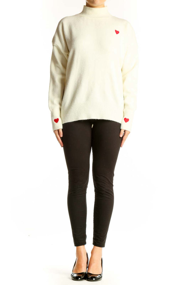 Front view of cream SilkRoll mock neck sweater with red heart on chest