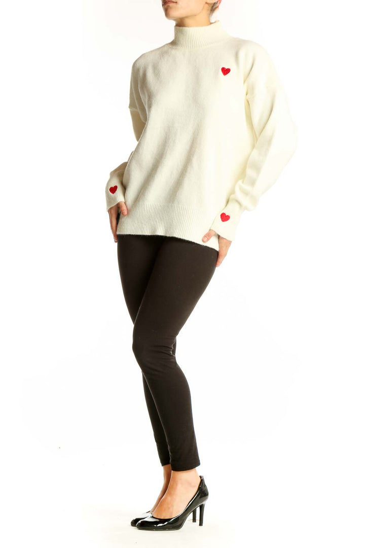 Front view of cream SilkRoll mock neck sweater with red heart on chest