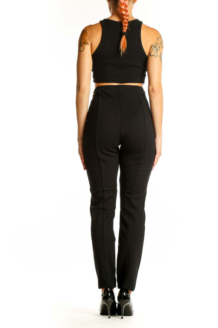 Side view of woman wearing I.N.C black high-waisted slim fit pants with crop top