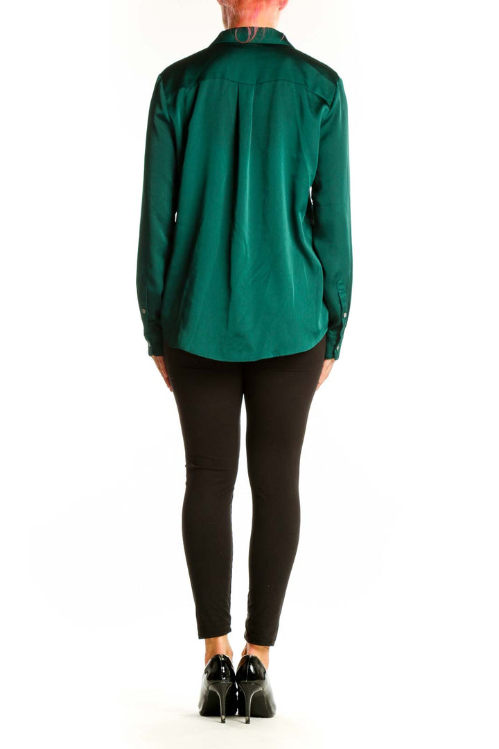 Back view of emerald green satin button-down blouse from J.Crew on model