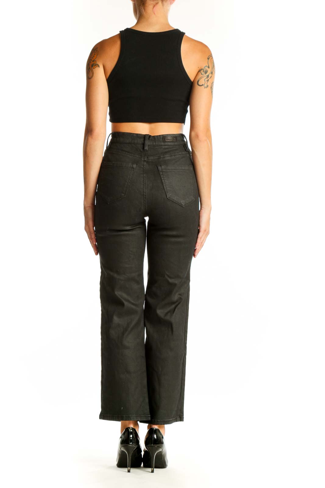 Side view of BLANKNYC black high-waisted wide-leg jeans on model with crop top
