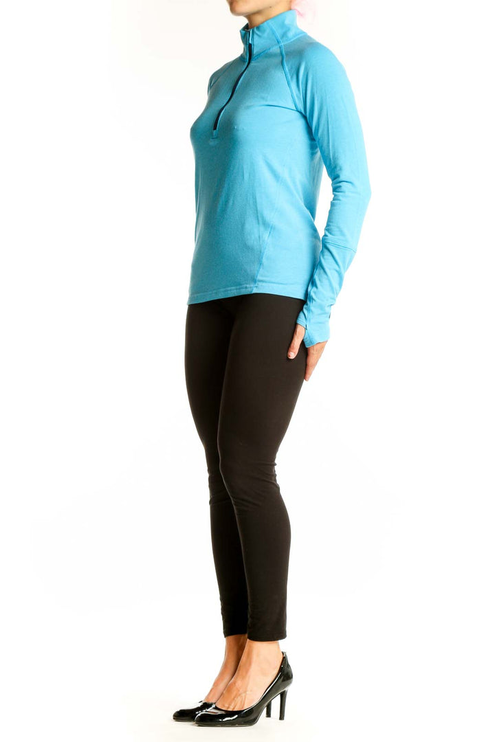 Front view of Stio turquoise half-zip athletic top