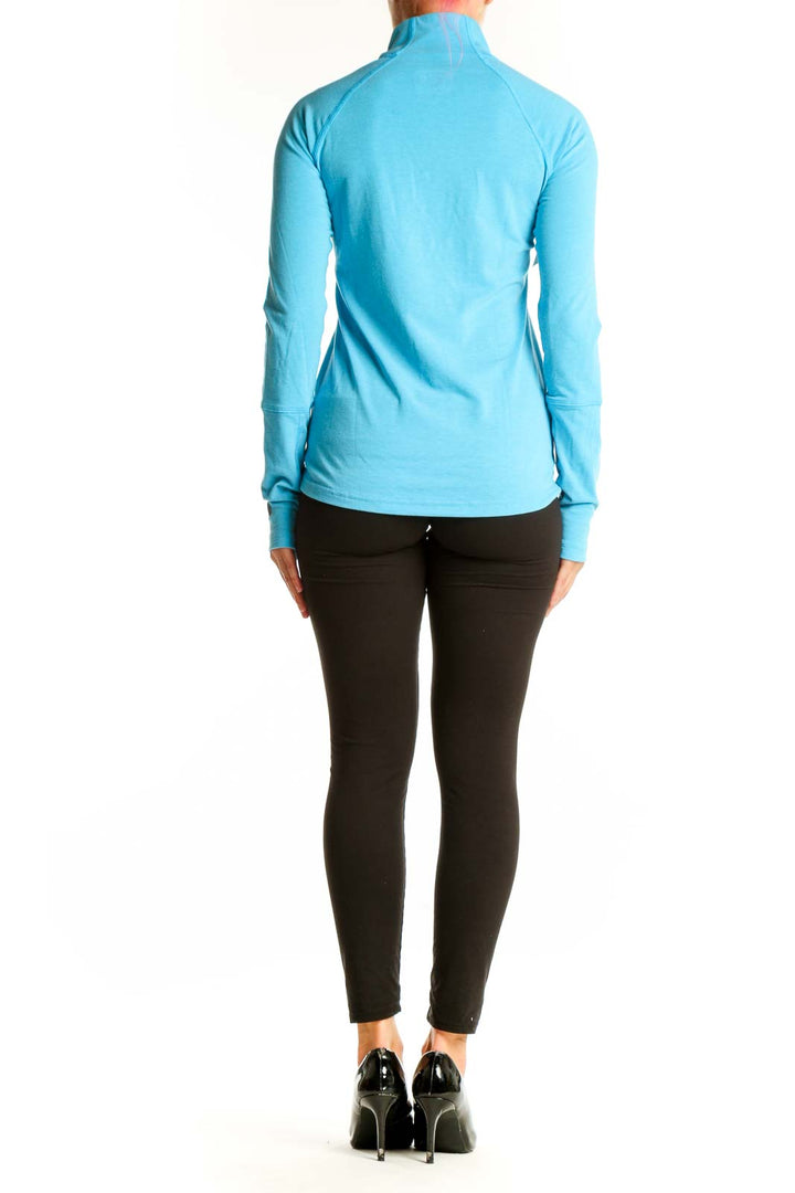 Side view of woman wearing Stio turquoise half-zip athletic top