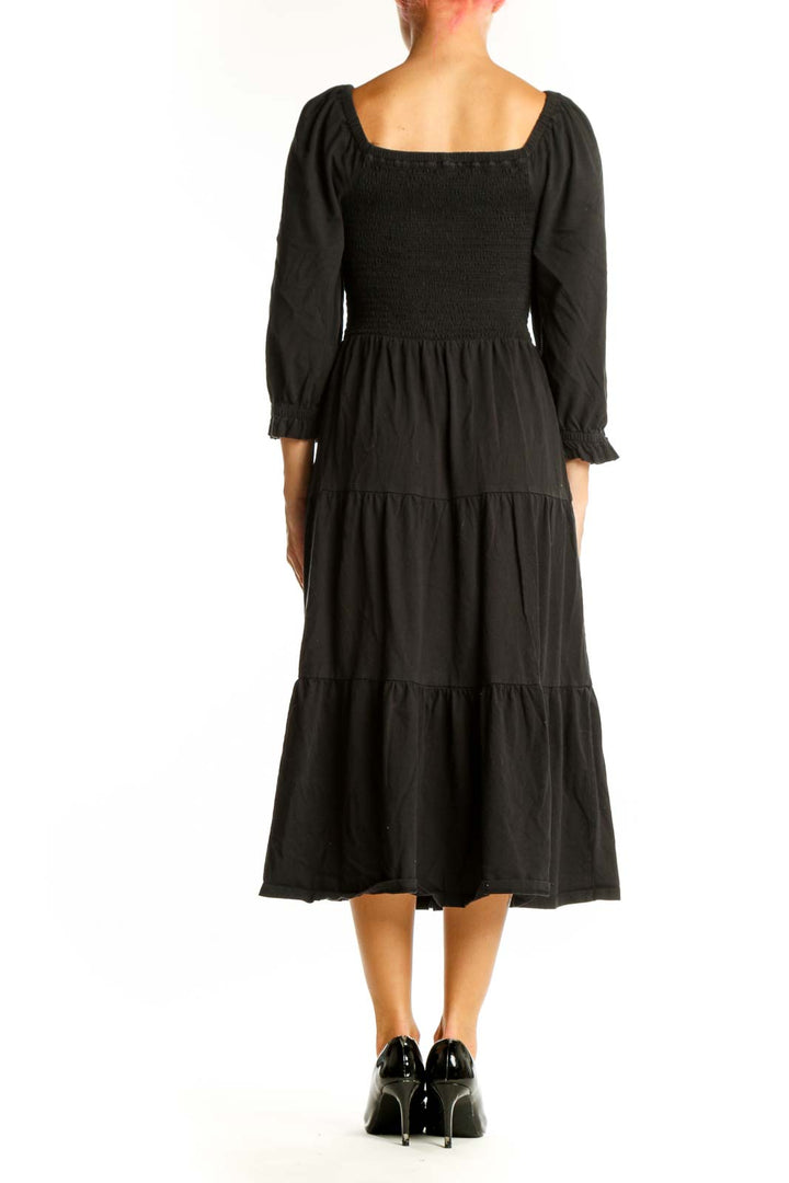 Side view of J.Crew black cotton midi dress showing tiered skirt and puff sleeves