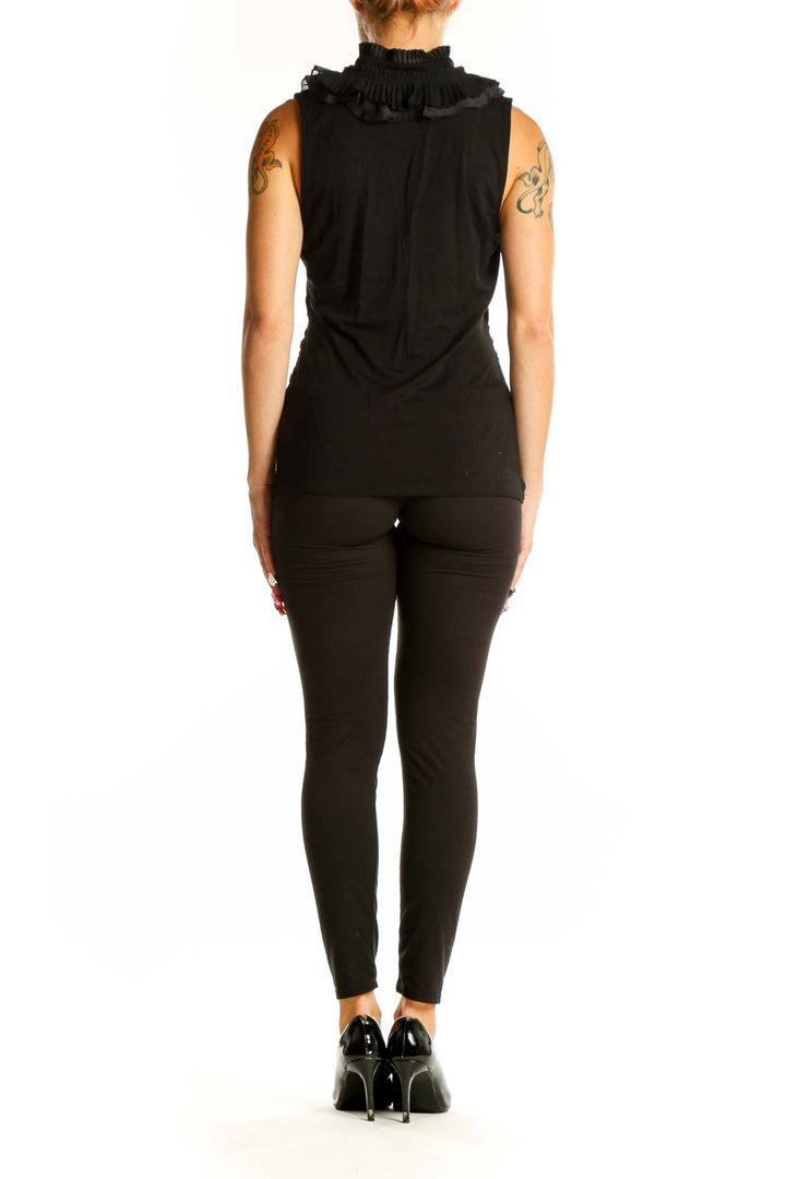 Side view of woman wearing black ruffle-neck sleeveless top from White House Black Market