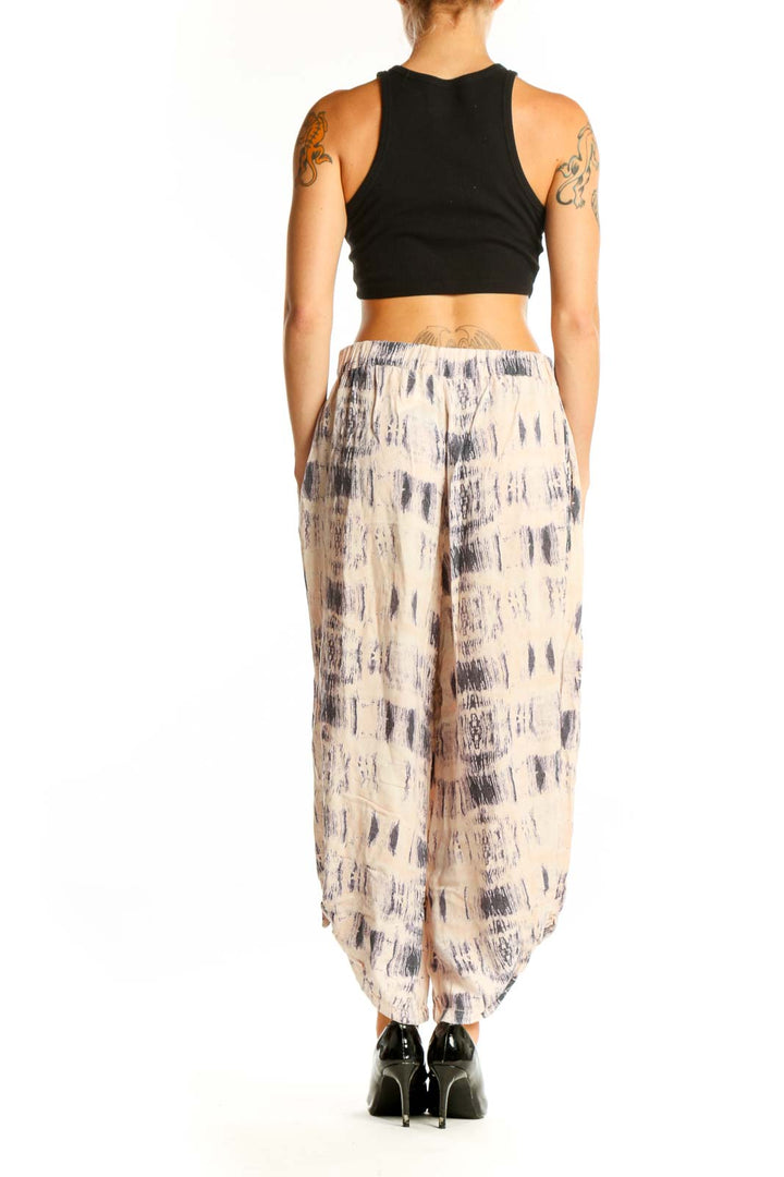 Side view of woman wearing Elevenses beige tie-dye wide-leg cotton pants with black crop top