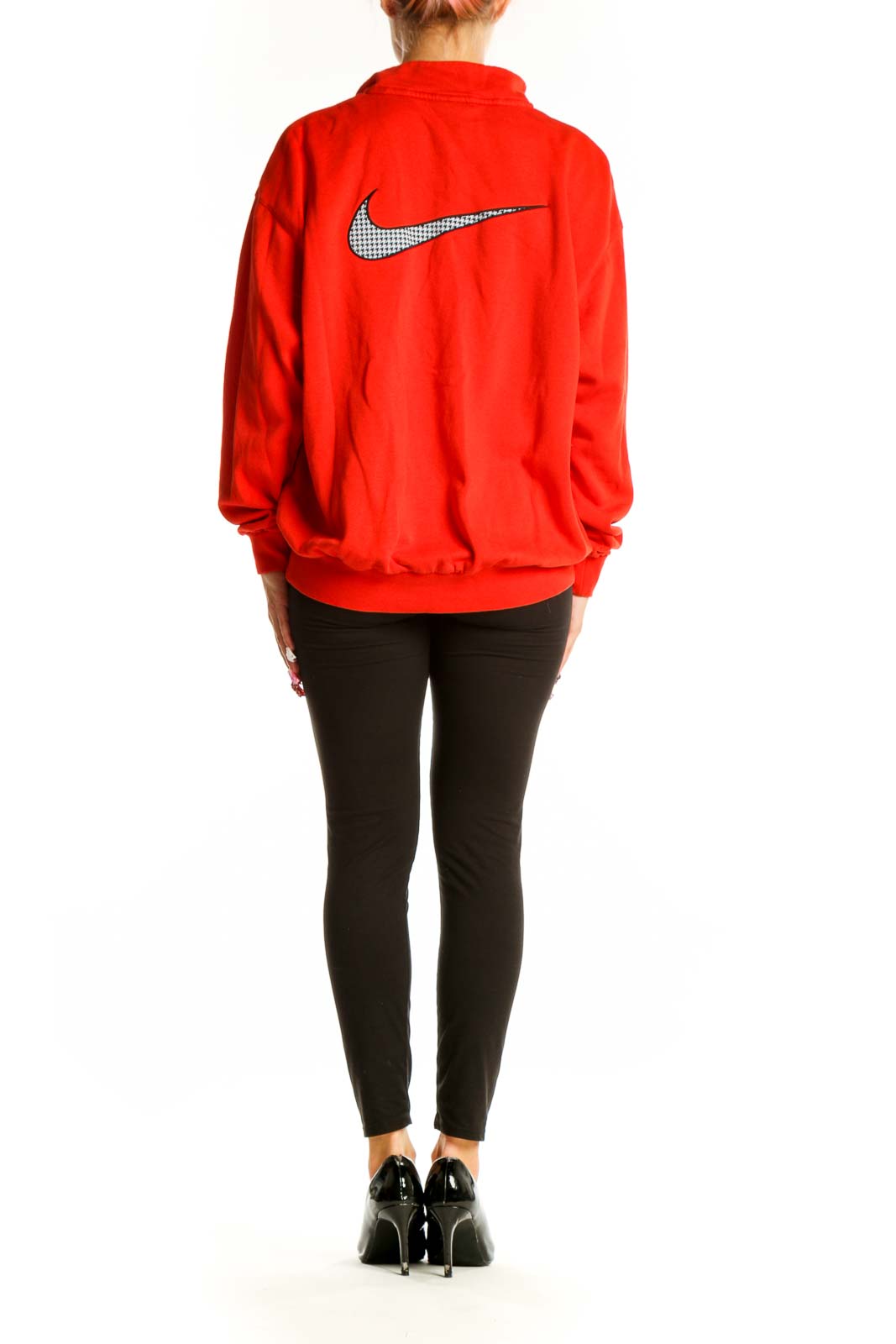 Side view of person wearing red Nike half-zip pullover sweatshirt with black pants