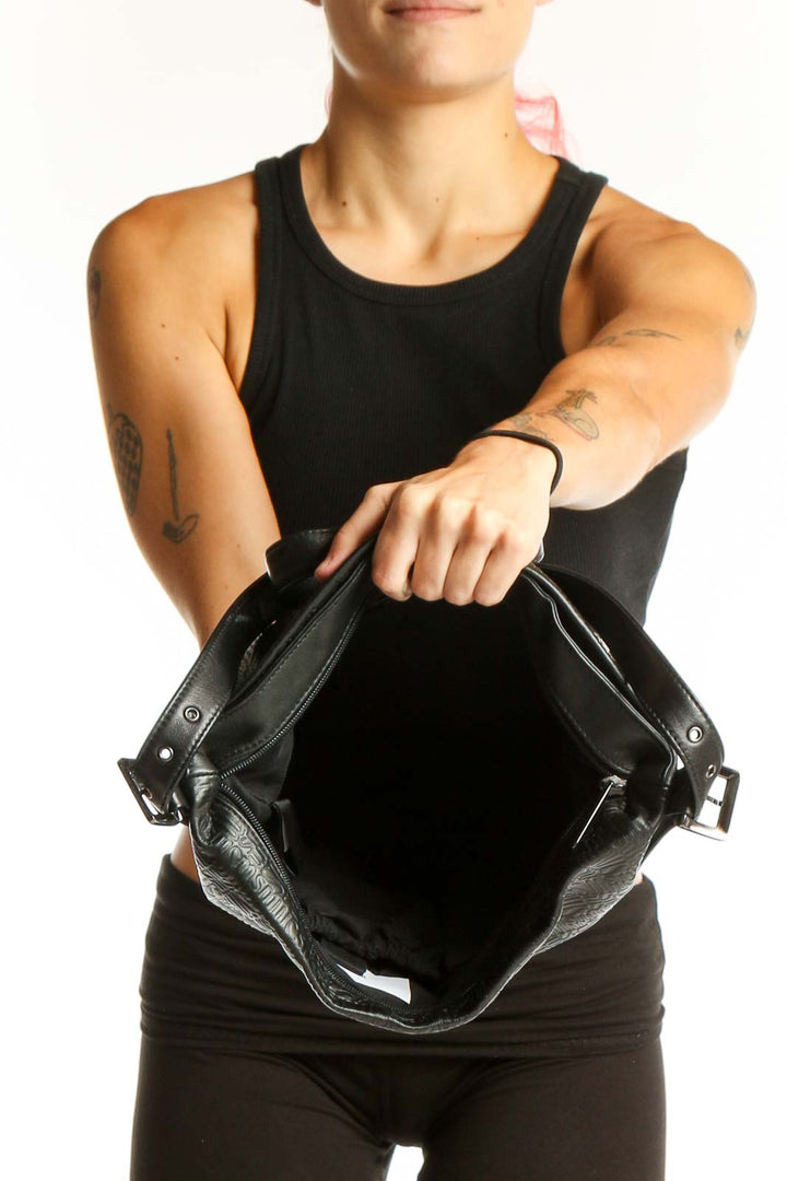 Side view of Stone Mountain black leather embossed shoulder bag worn by model