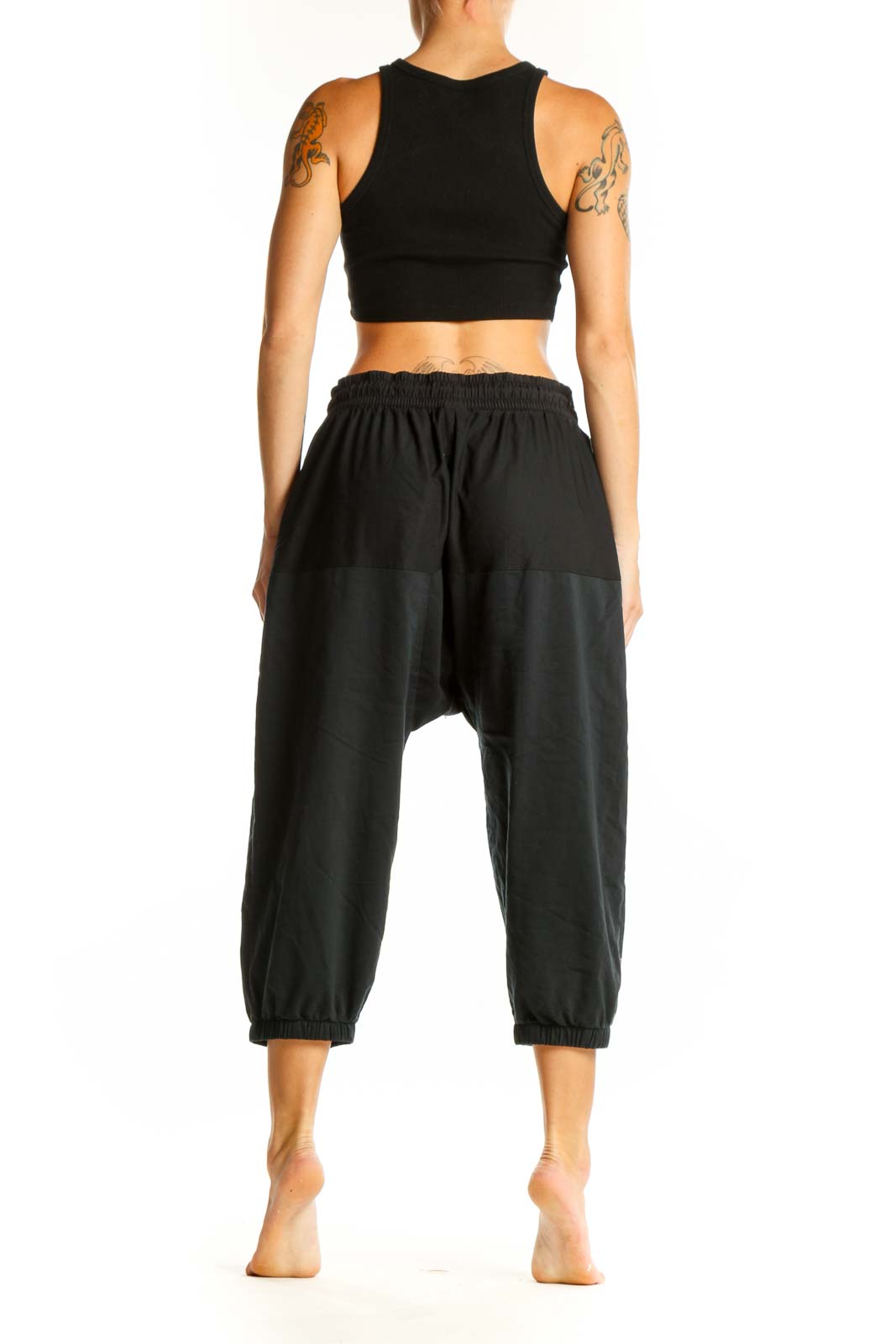 Side view of woman wearing black Nike cropped jogger pants and crop top