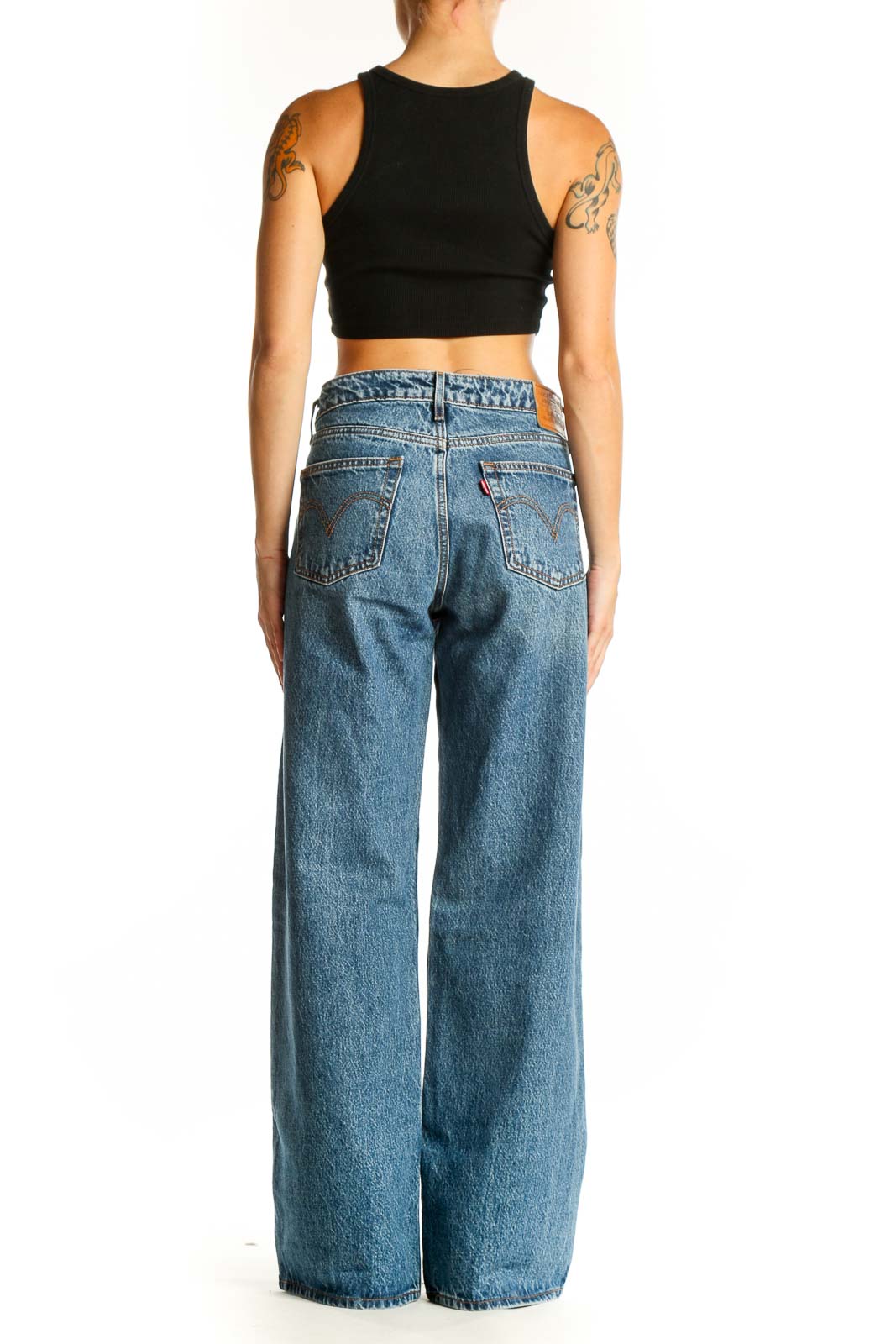 Side view of blue wide-leg Levi's jeans on model with black crop top