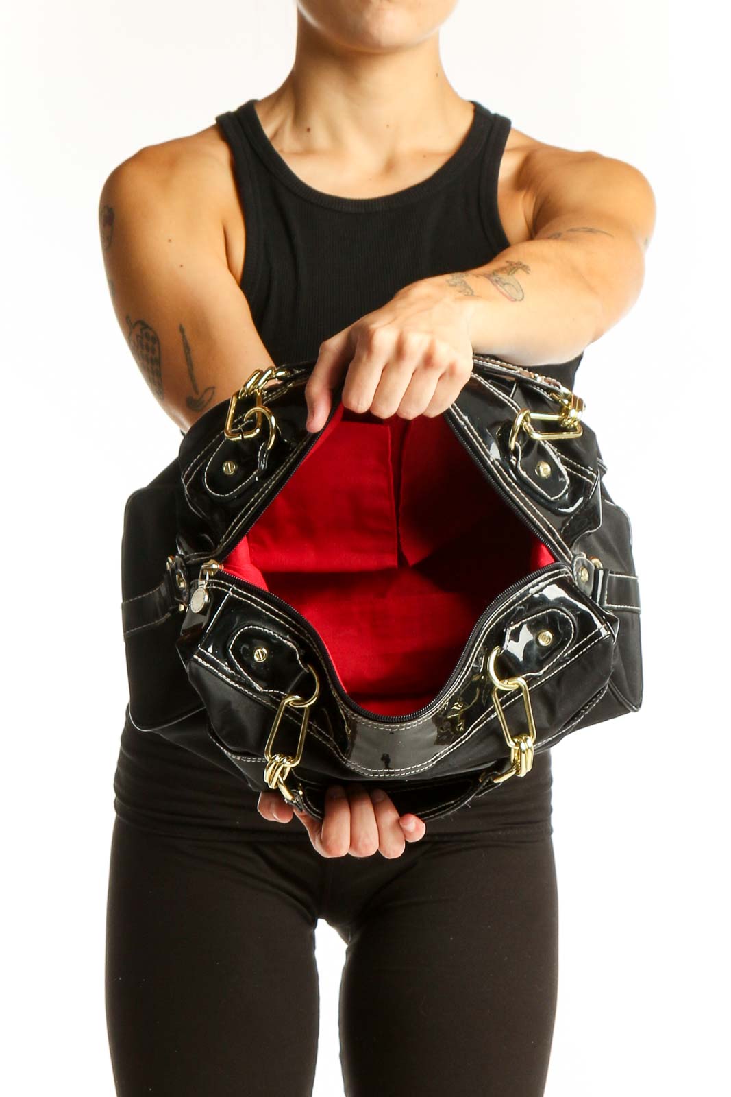 Model carrying Issac Mizrahi black shoulder bag with gold chain strap