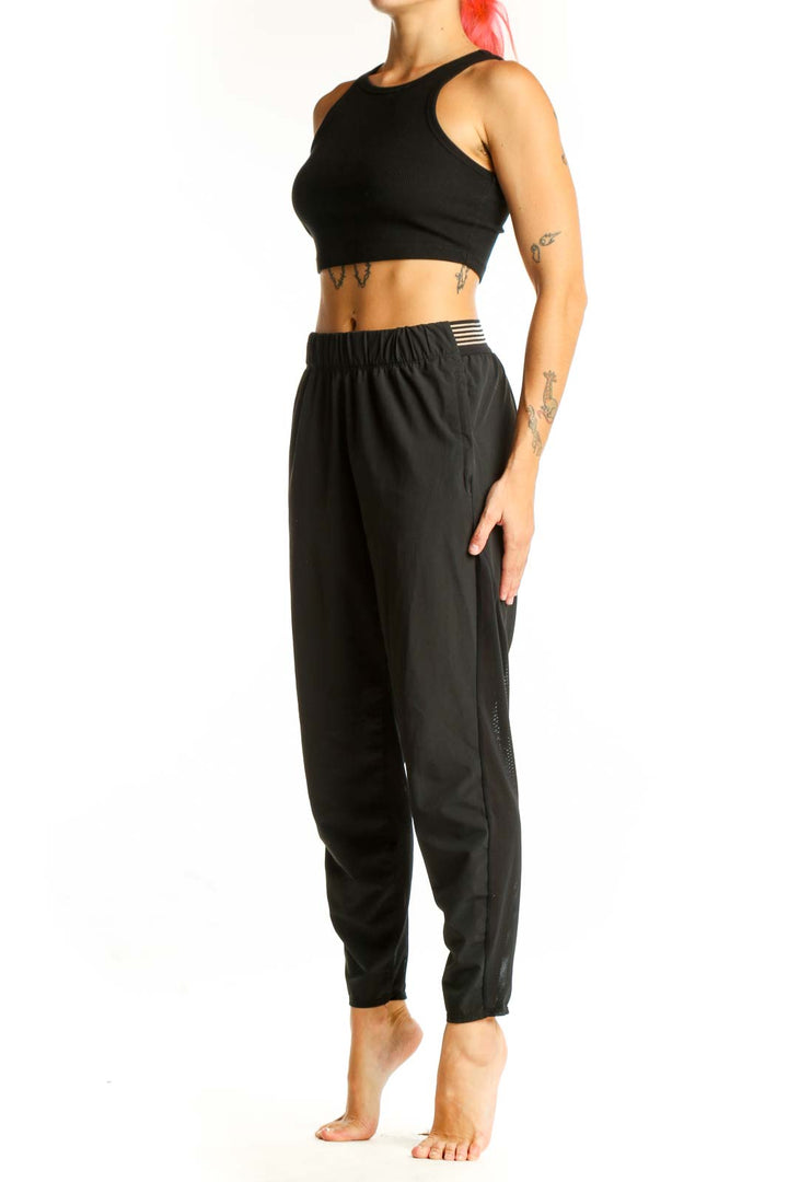 Front view of black Nike athletic performance pants with tapered leg