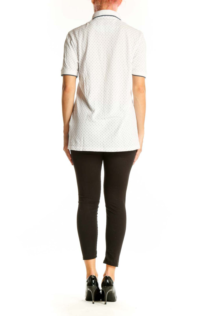Side view of model wearing Ted Baker London white polka dot polo shirt with black pants