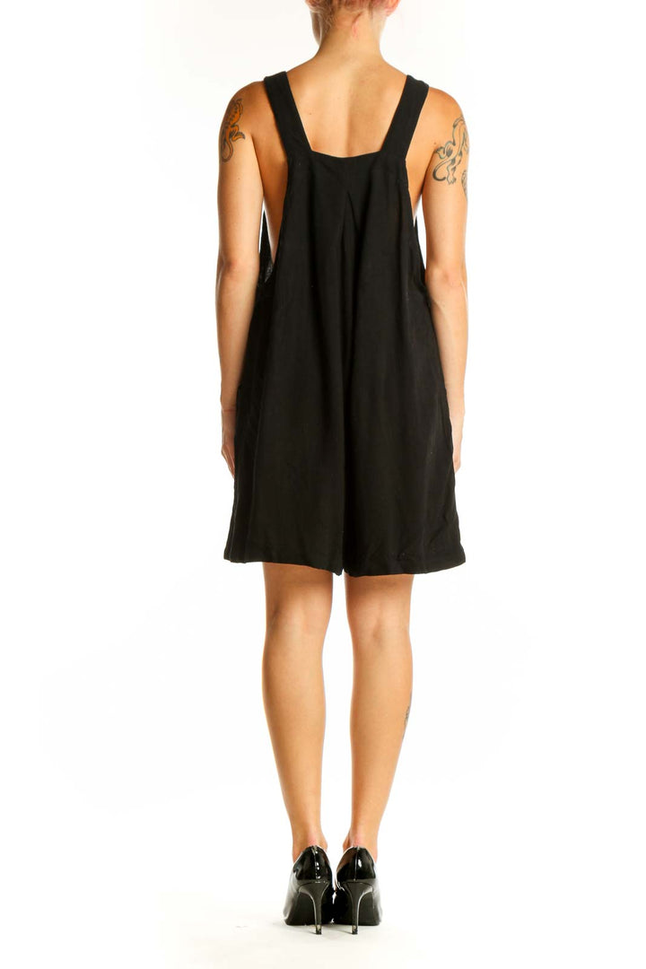 Side view of Arabess black sleeveless overalls dress showing relaxed fit and pockets