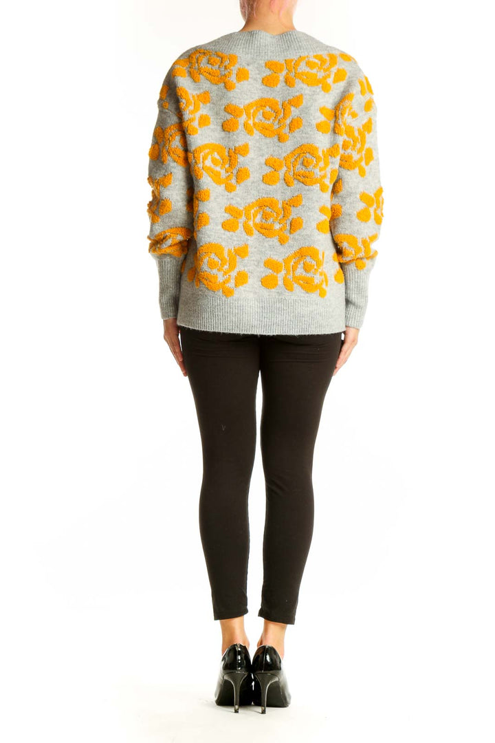 Side view of model wearing gray and yellow floral V-neck sweater