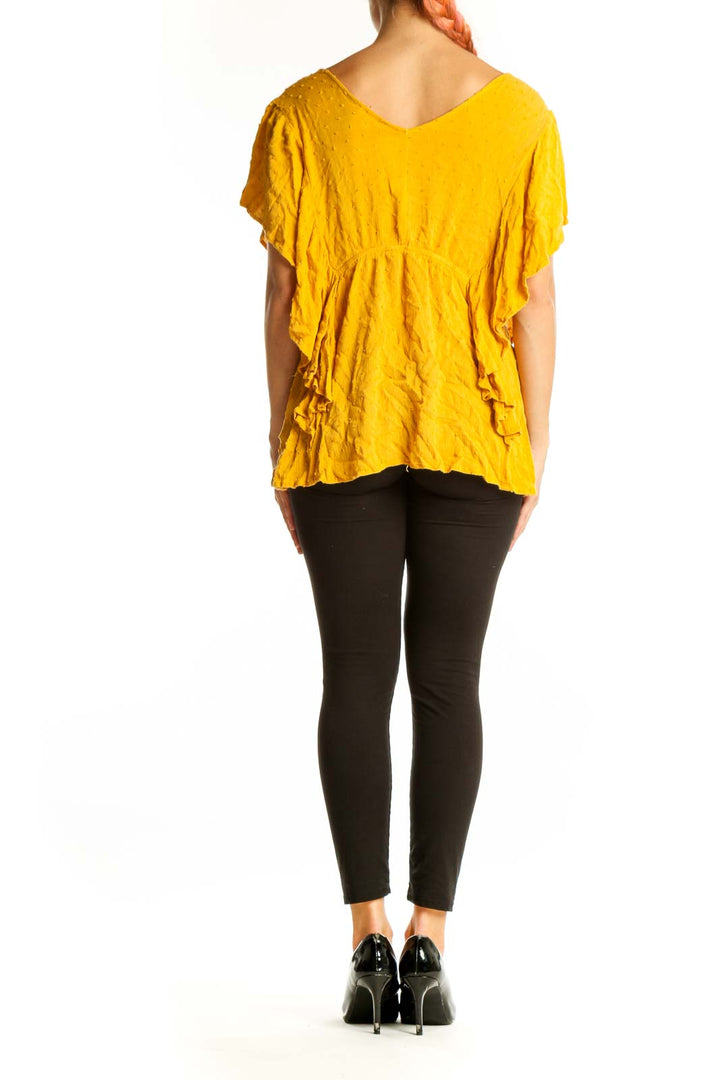 Side view of yellow KORI America flowy top on model with black pants