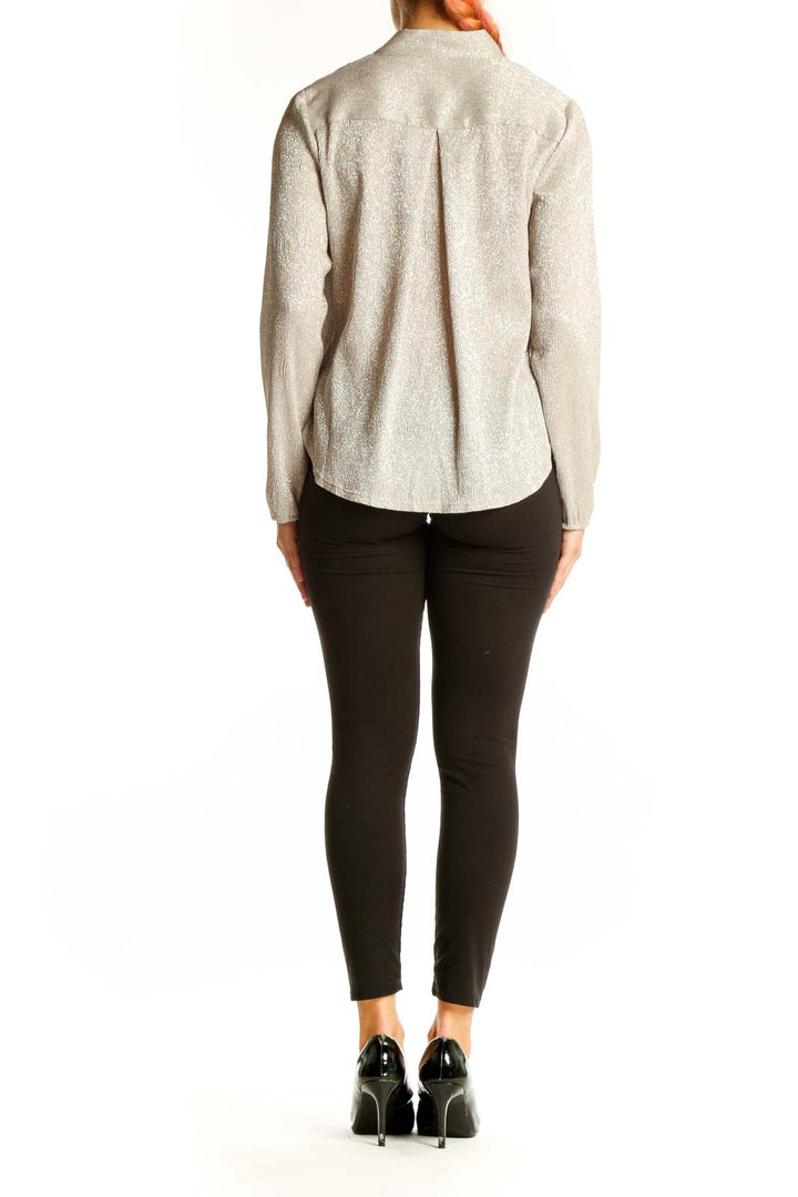 Side view of Alfani beige shimmering wrap-style blouse on model with black pants