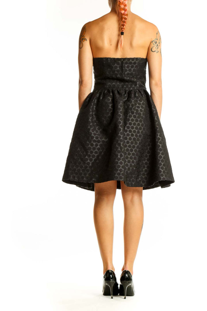 Side view of Wendy Katlen black polka dot strapless cocktail dress showing fitted bodice and flared skirt