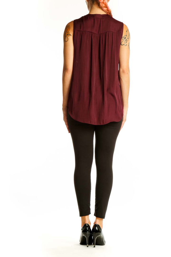 Side view of model wearing Vince Camuto burgundy sleeveless top with black pants