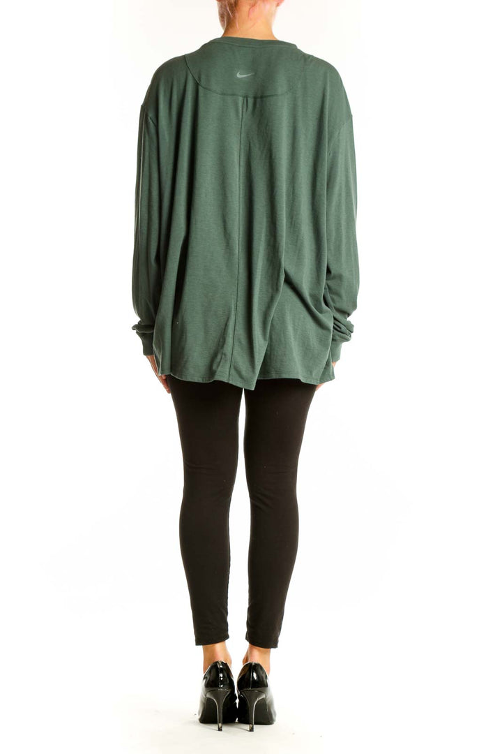 Back view of green Nike oversized long sleeve athletic top on model