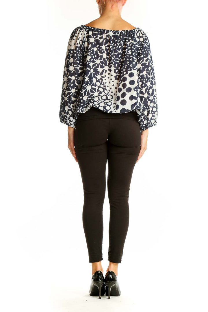 Side view of model wearing Trina Turk Navy and White Floral Print Peasant Top with black pants