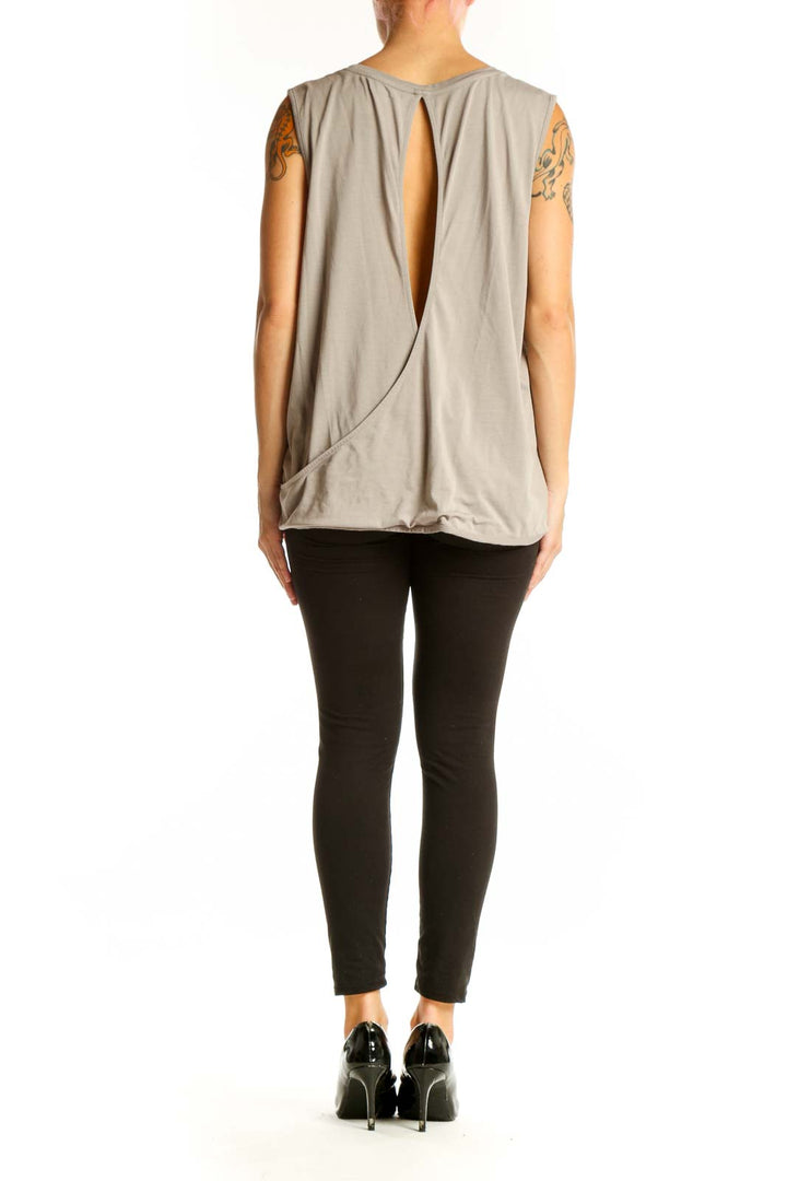 Side view of model wearing Athleta taupe sleeveless tank top with black pants