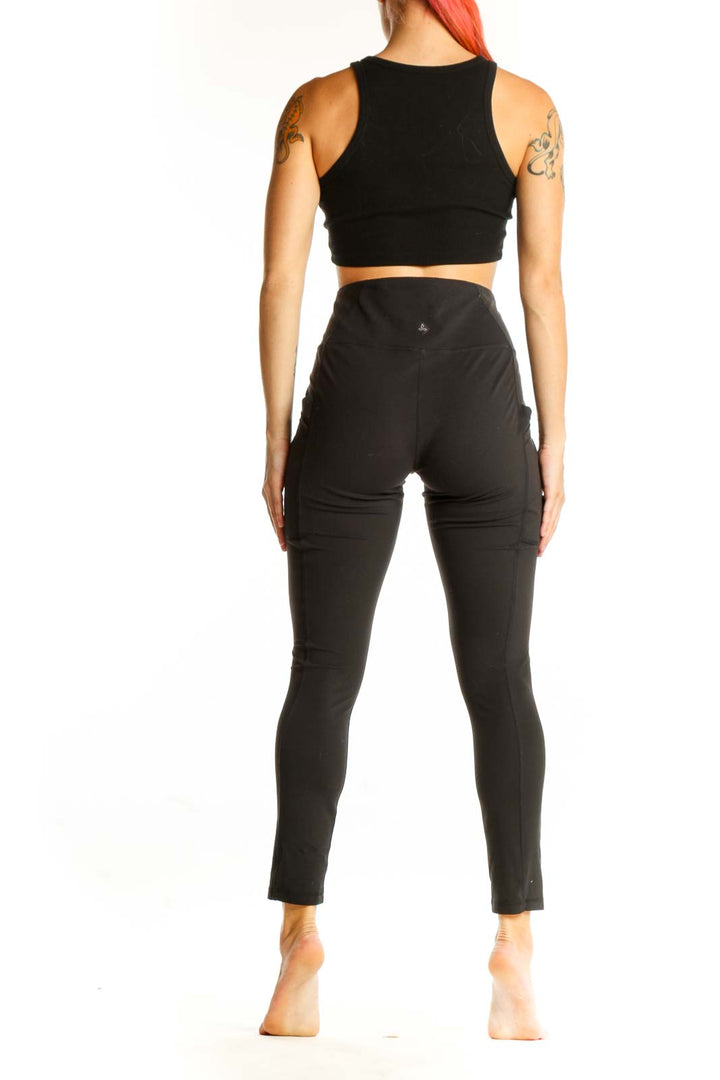 Side view of woman wearing black prAna high-waisted leggings and matching top