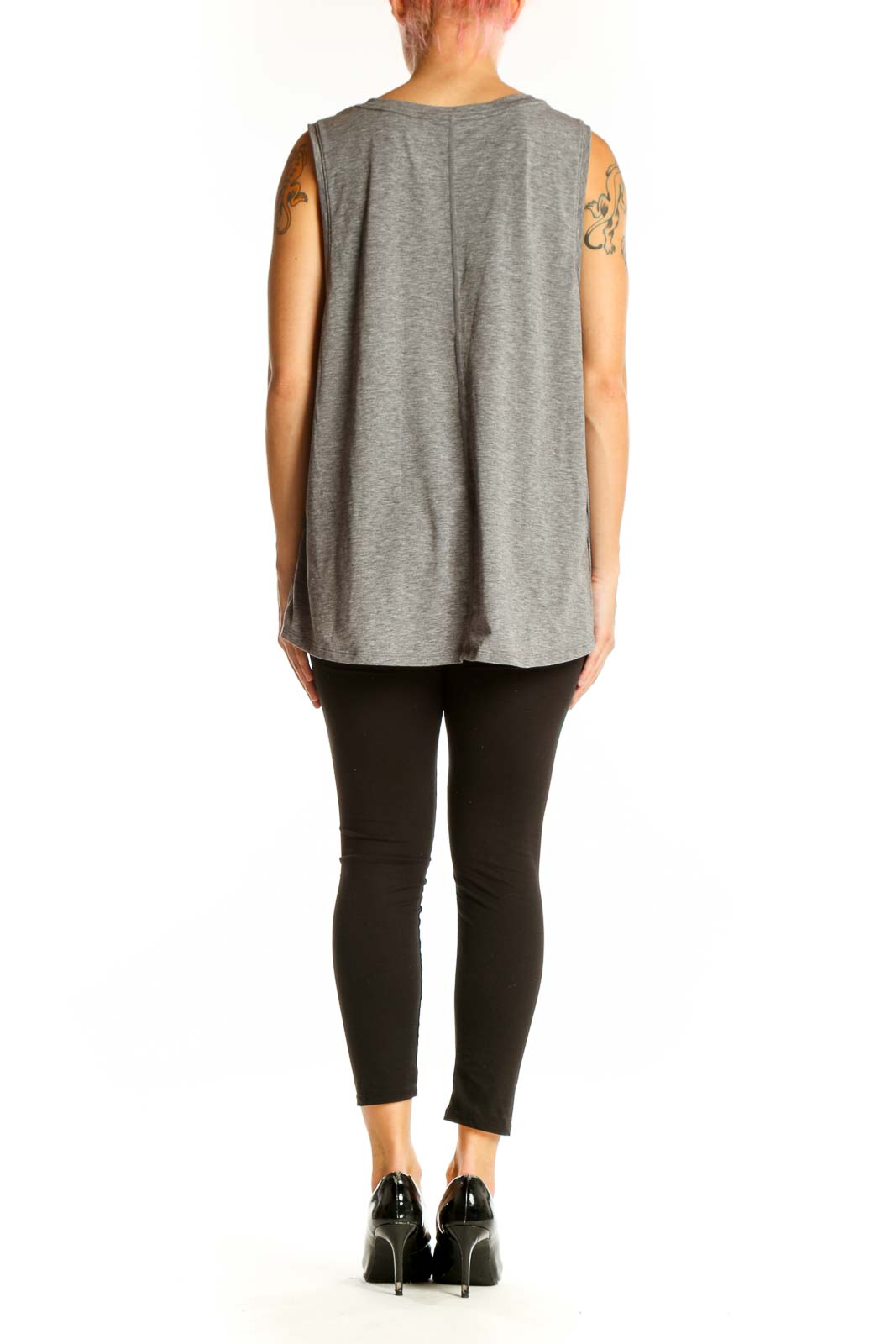 Side view of model wearing gray GapFit sleeveless tank top with black leggings