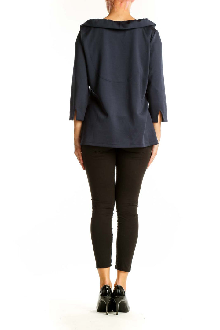 Side view of navy ruffled V-neck blouse on model