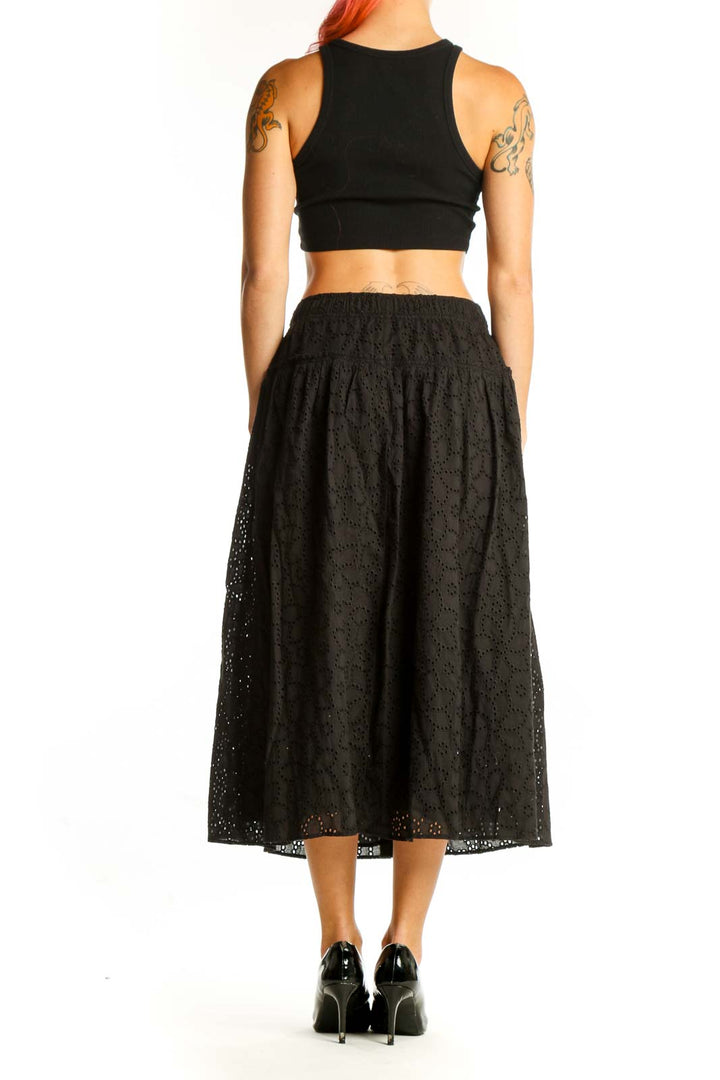 Side view of model wearing Madewell black eyelet lace cotton midi skirt