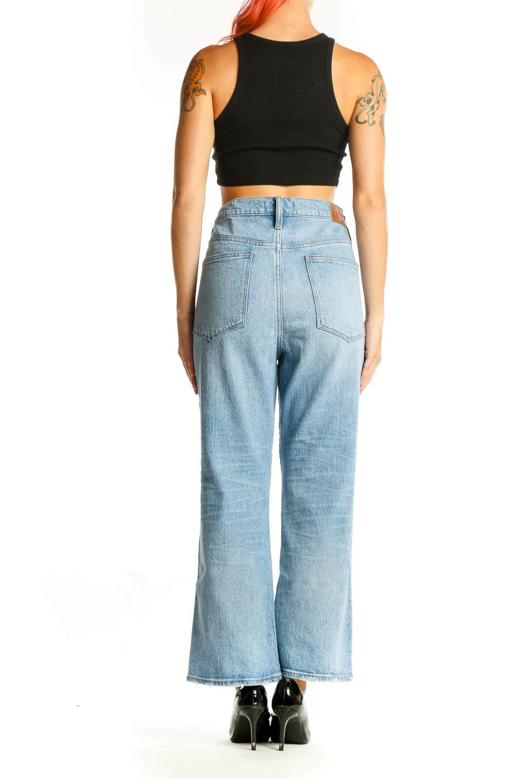 Side view of model wearing Madewell light blue wide-leg jeans with black crop top