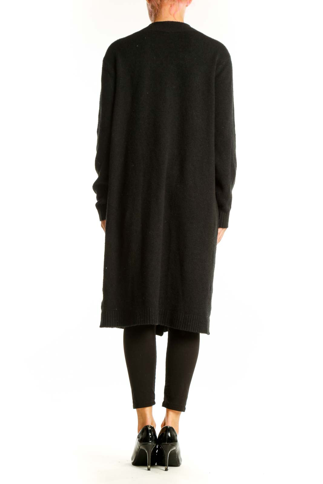 Side view of Cabi black long button-up cardigan on model with hand in pocket
