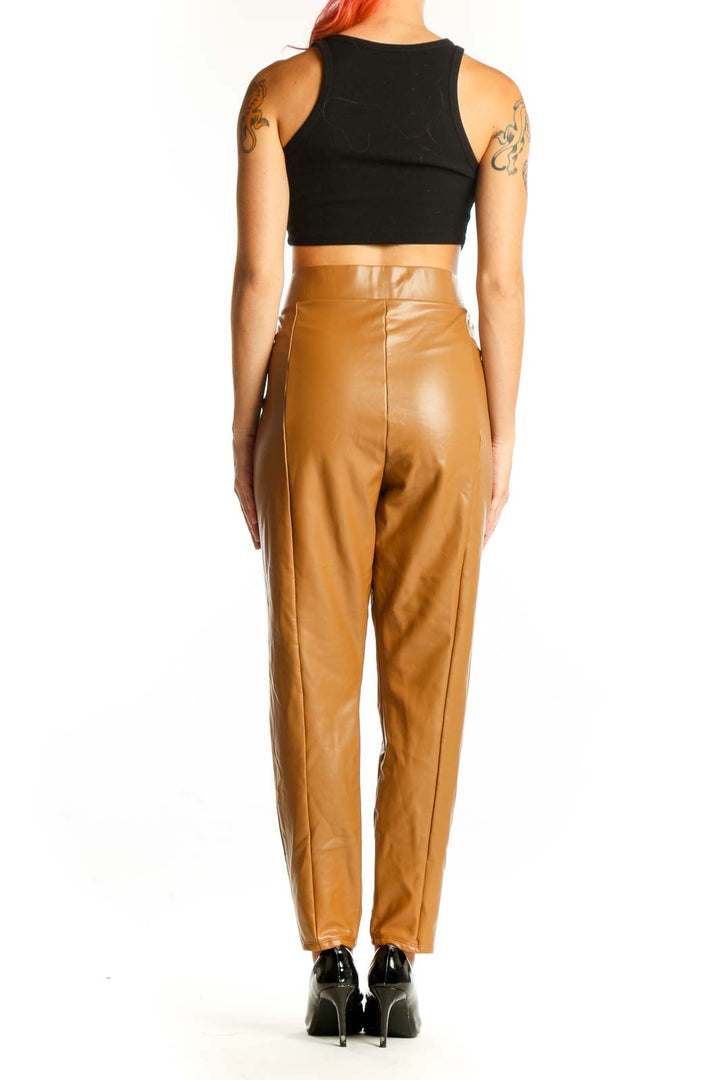 Side view of model wearing LOFT camel faux leather pants with black crop top