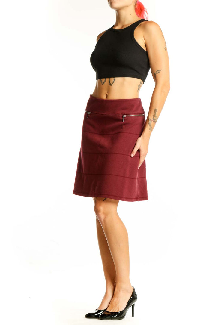 Front view of burgundy A-line skirt with zip pockets
