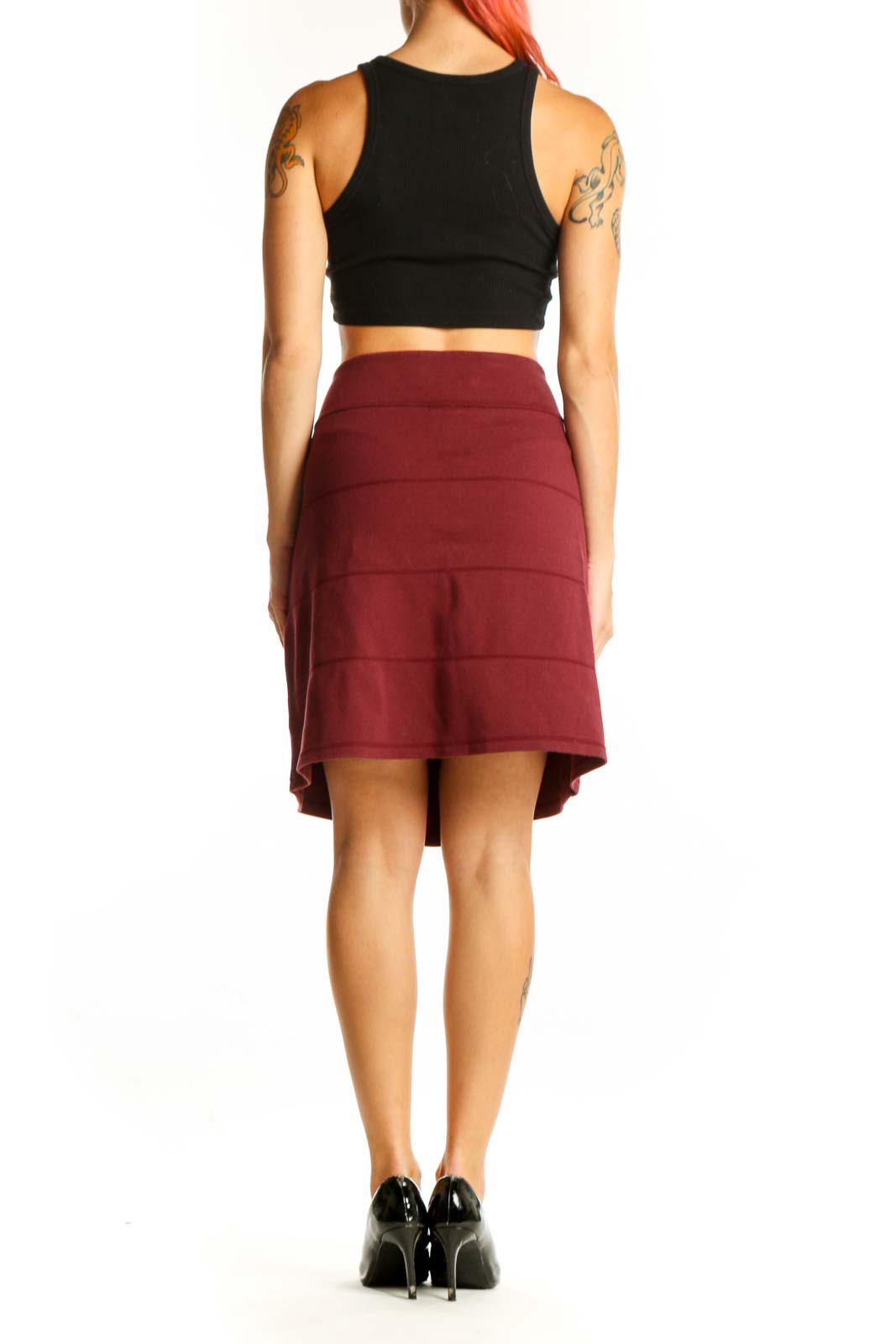 Side view of burgundy A-line skirt on model with black top