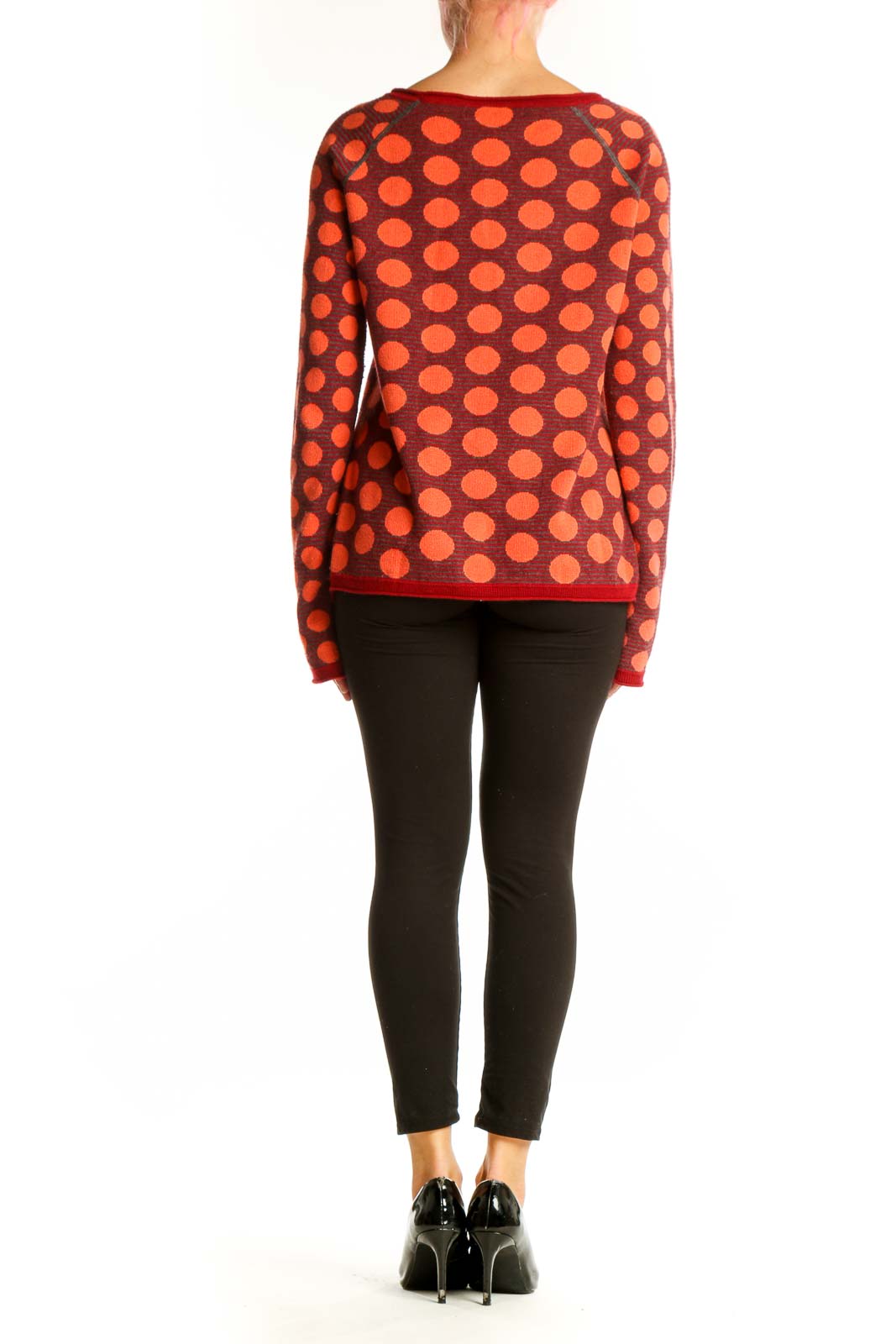 Side view of woman wearing Title Nine red polka dot sweater with black pants