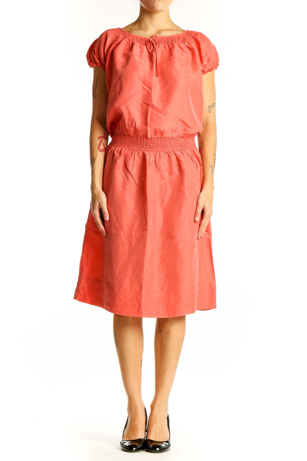 Front view of coral silk peasant dress with puff sleeves and smocked waist