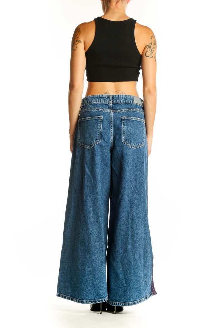 Side view of model wearing Zara Basic blue wide-leg denim jeans with colorful side stripes